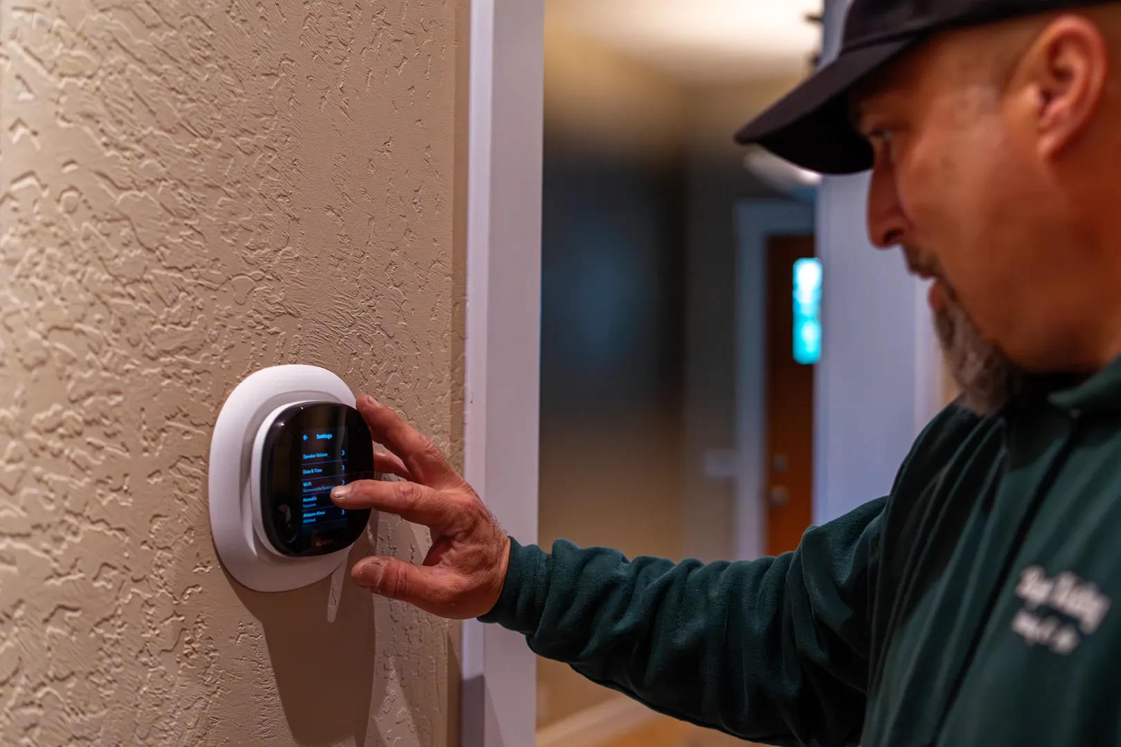 Electrician testing a smart home thermostat after installation in Grants Pass residential.