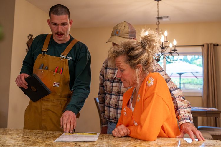 HVAC technician explaining HVAC options to homeowners in Grants Pass.