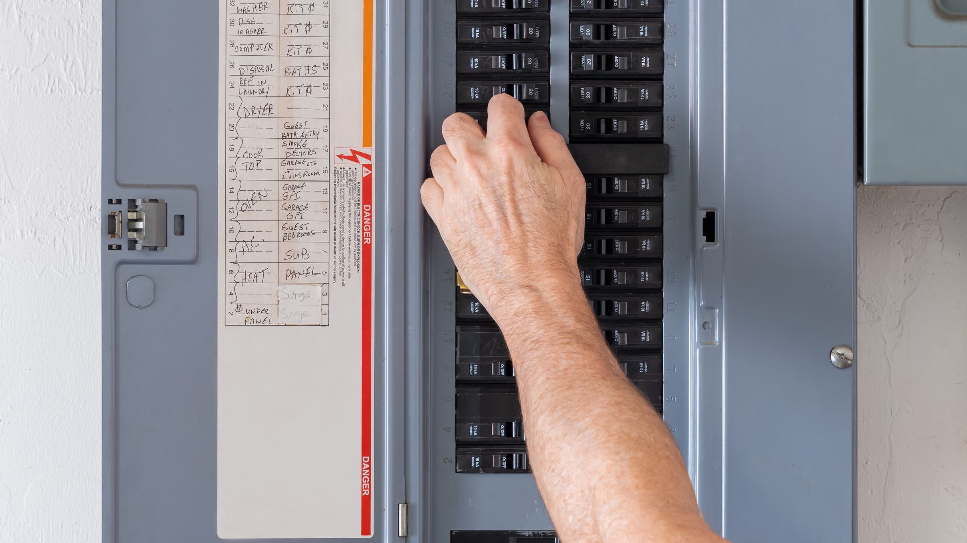 Image of a homeowner turning off one of their electrical breakers