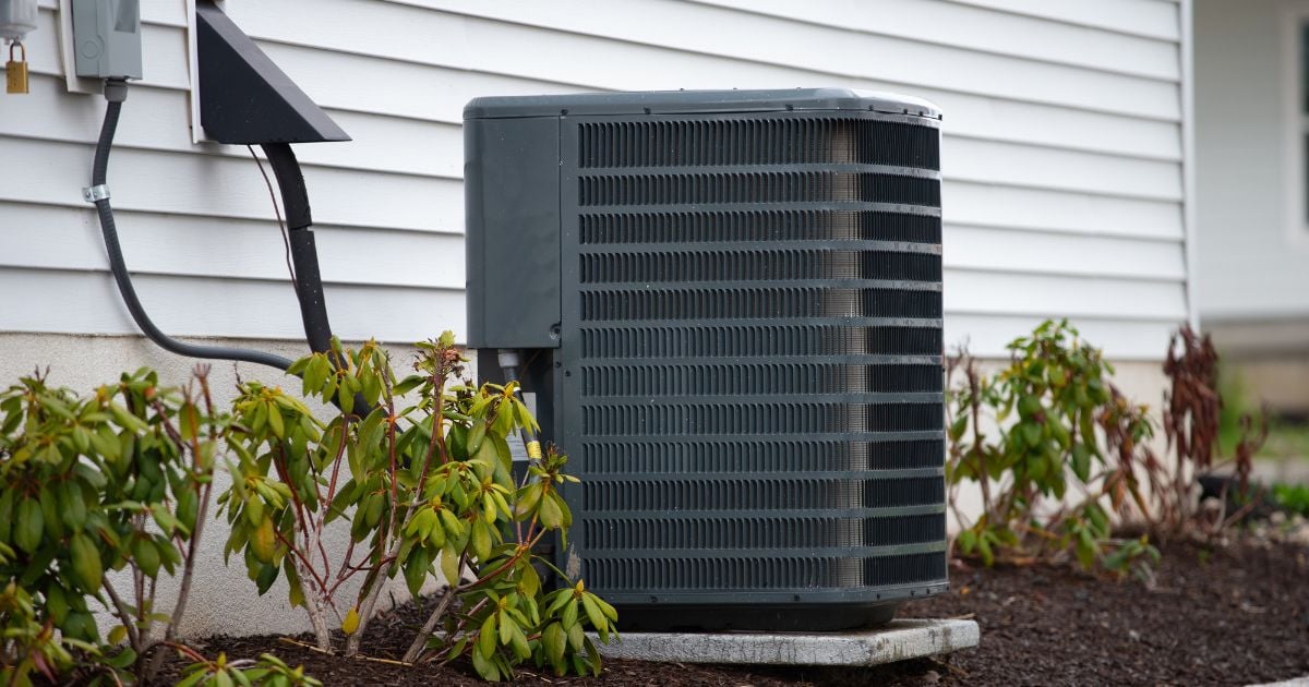 Large air conditioning unit stands on concrete slabs beside a residential house in Grants Pass.