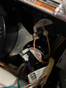 Technician inspecting furnace pressure switch components in Medford, OR.