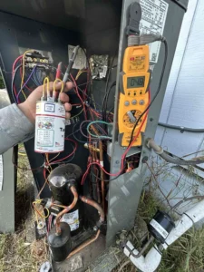 Grants Pass HVAC repair technician replacing a failed component affecting cooling performance